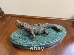Shared bronze crocodile sculpture on a green marble base after Milo