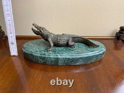 Shared bronze crocodile sculpture on a green marble base after Milo