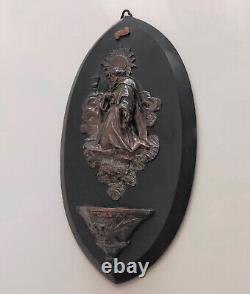 Wall-mounted bronze sculpture signed on a marble plaque