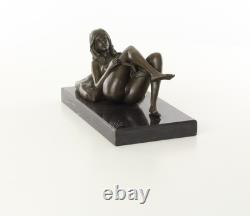 Sculpture d'une Femme nue allongée sur un socle en marbre noir d'après J. Mavchi