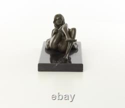 Sculpture d'une Femme nue allongée sur un socle en marbre noir d'après J. Mavchi