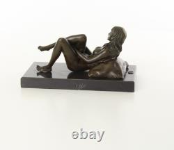 Sculpture d'une Femme nue allongée sur un socle en marbre noir d'après J. Mavchi