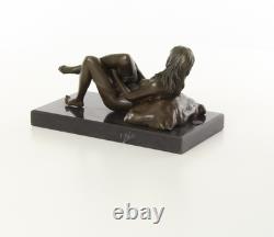 Sculpture d'une Femme nue allongée sur un socle en marbre noir d'après J. Mavchi