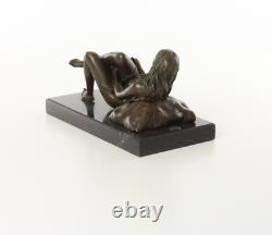 Sculpture d'une Femme nue allongée sur un socle en marbre noir d'après J. Mavchi