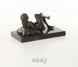 Sculpture d'une Femme nue allongée sur un socle en marbre noir d'après J. Mavchi