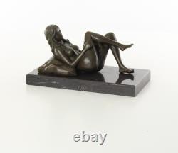 Sculpture d'une Femme nue allongée sur un socle en marbre noir d'après J. Mavchi