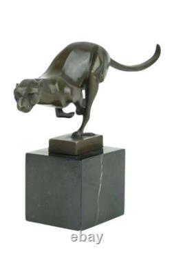Sculpture en bronze d'un guépard courant sur un socle en marbre noir Signée