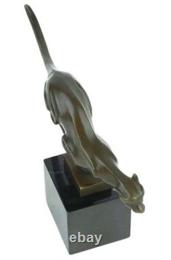 Sculpture en bronze d'un guépard courant sur un socle en marbre noir Signée