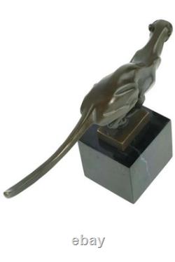 Sculpture en bronze d'un guépard courant sur un socle en marbre noir Signée